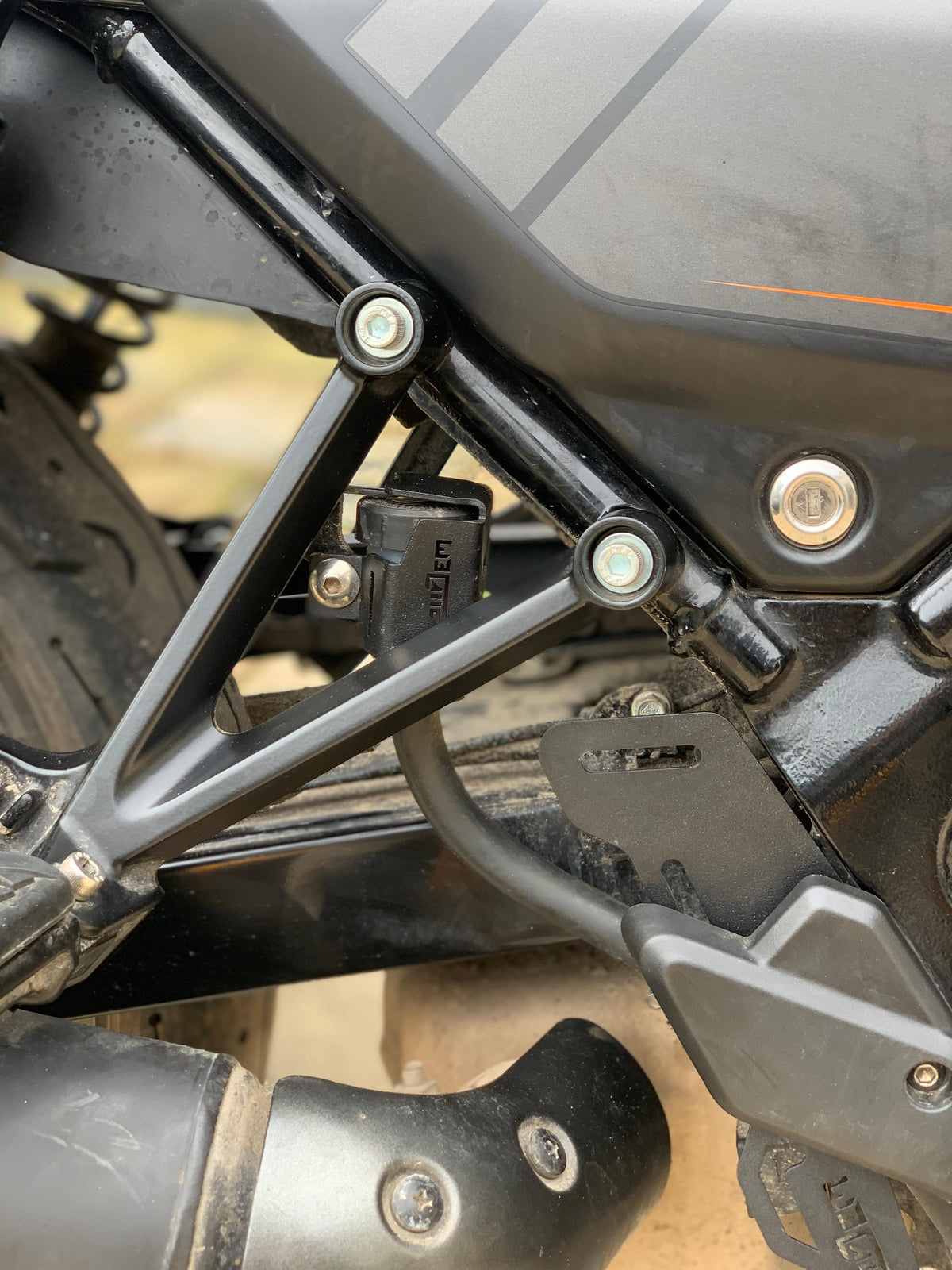 Harley X440 oil container guard by Jorjem International Pvt Ltd, shown mounted on the motorcycle's oil tank for protection.